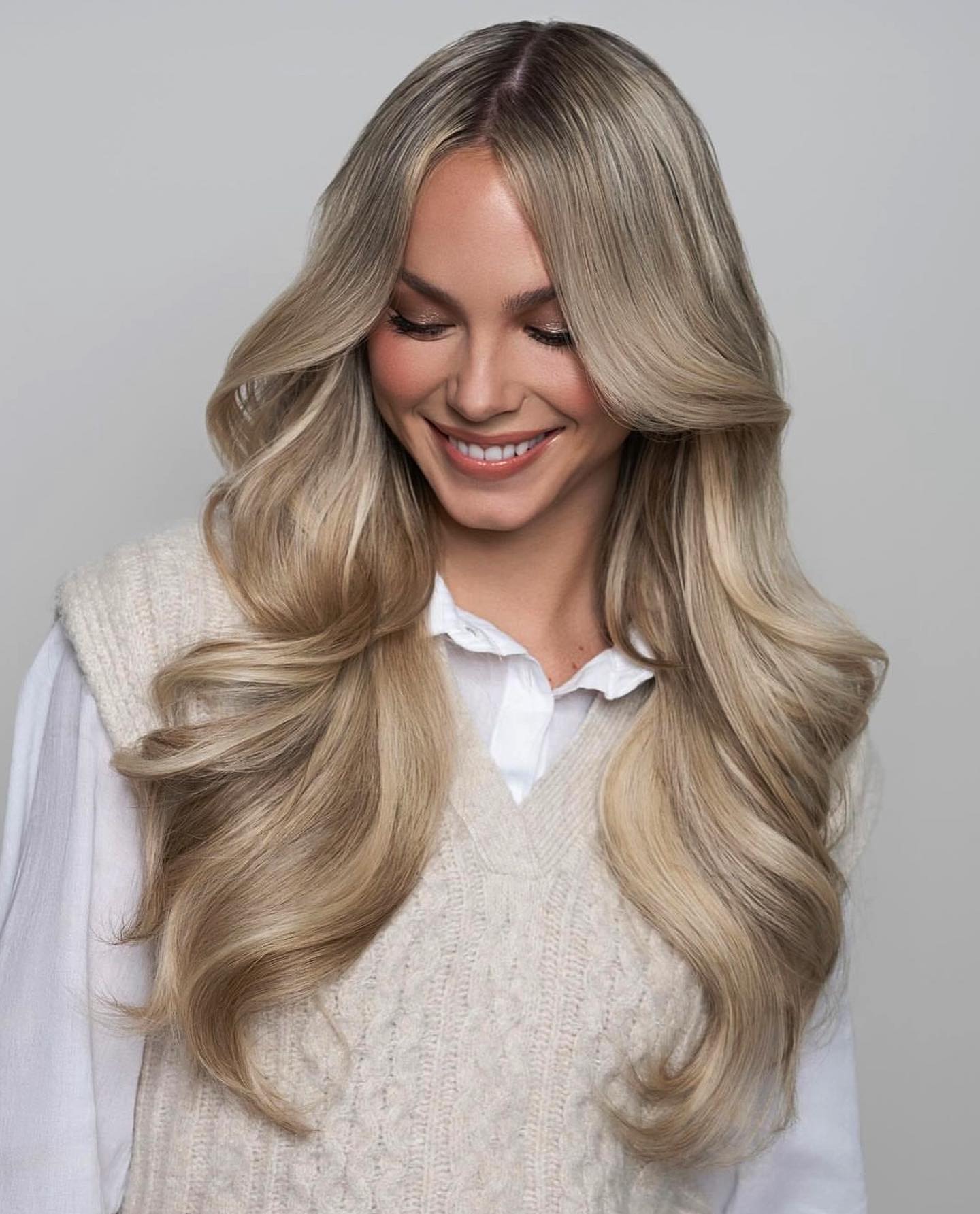 Modelka s dlhými blond vlasmi a jemným melírovaným efektom